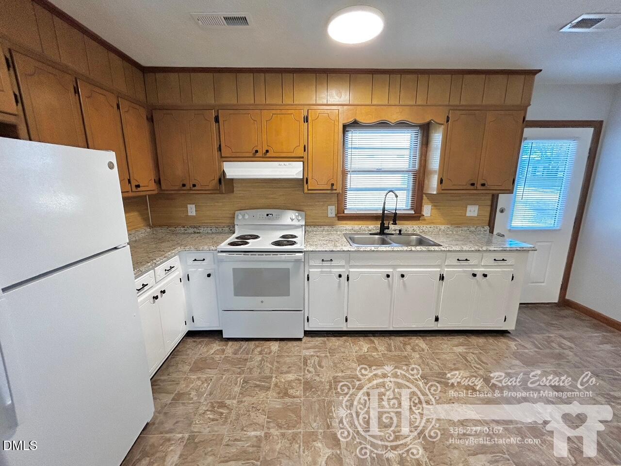 296 Seventh Avenue, Unit 3 Yanceyville, NC 27379 - Photo 9 of 21 a kitchen with granite countertop a sink a stove a refrigerator and cabinets