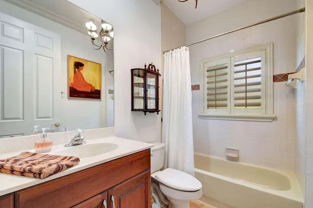 a bathroom with a granite countertop sink toilet a mirror and shower