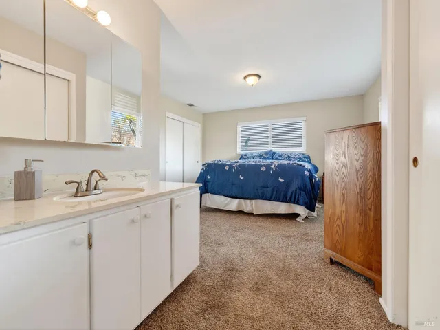 a spacious bedroom with a bed and cabinets