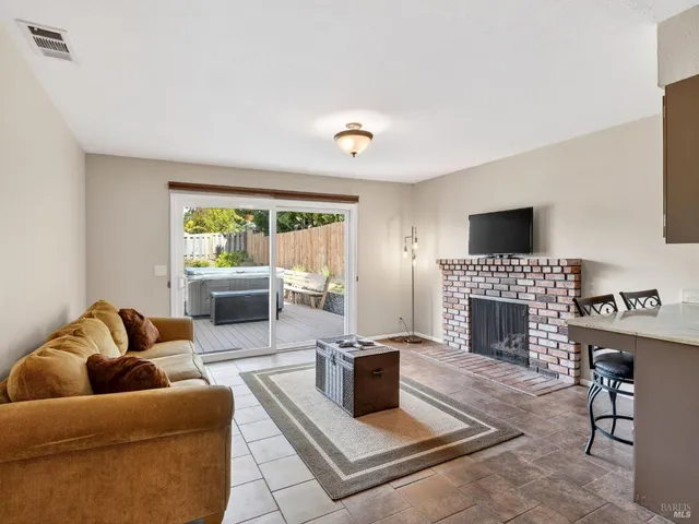 a living room with furniture a fireplace and a flat screen tv