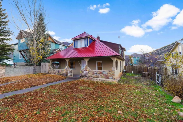 a front view of a house with yard and sitting area