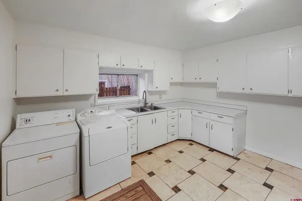 a kitchen with white cabinets appliances and a sink