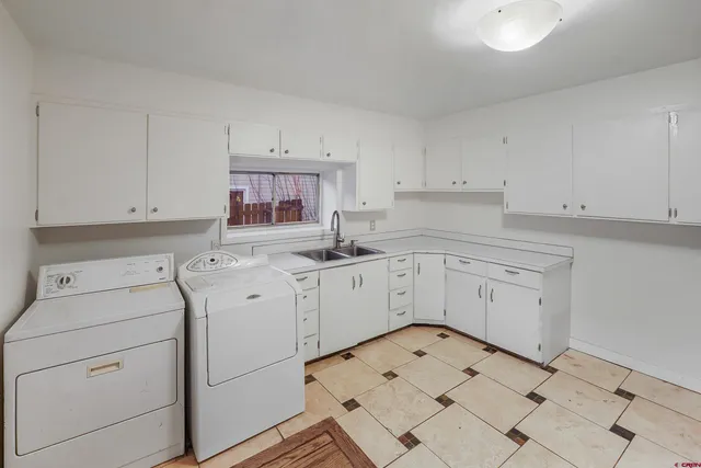 a kitchen with white cabinets appliances and a sink
