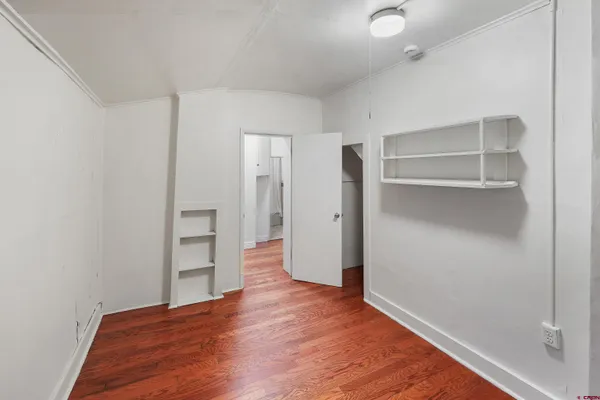 a view of empty room with wooden floor