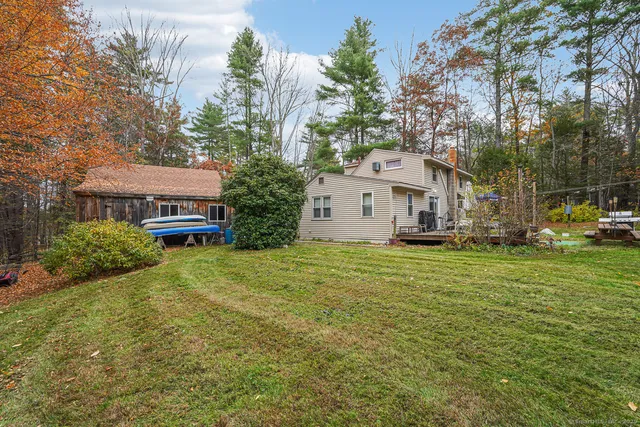 a view of a house with a big yard and large trees