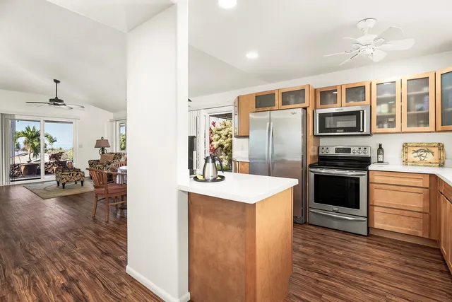 a kitchen with stainless steel appliances kitchen island granite countertop a stove and a refrigerator