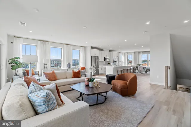 a living room with furniture and kitchen view