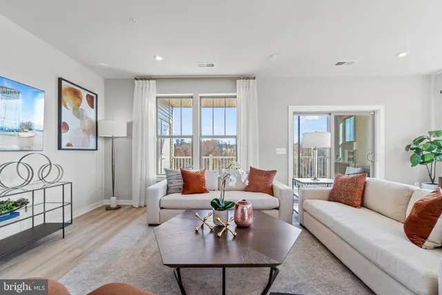a living room with furniture and floor to ceiling windows