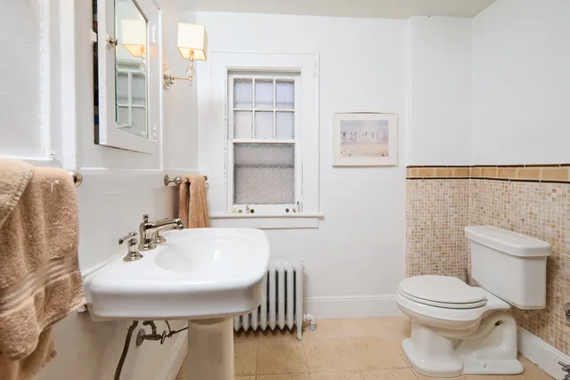 a bathroom with a sink a toilet and a mirror