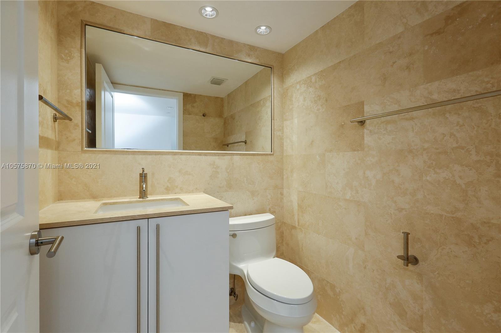 8925 Collins Avenue, Unit 9B Surfside, FL 33154 - Photo 11 of 46 a bathroom with a granite countertop sink toilet and a mirror