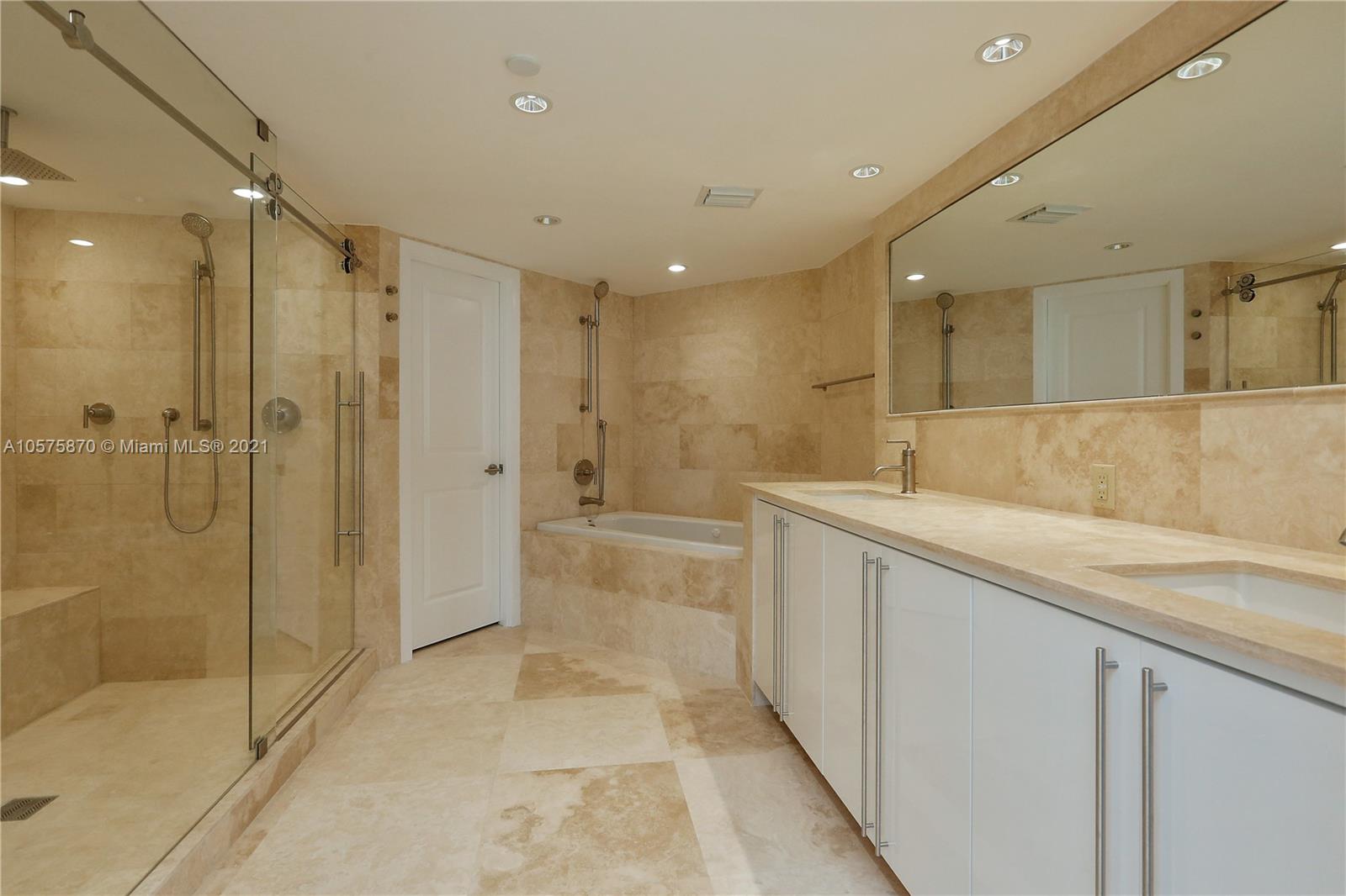 8925 Collins Avenue, Unit 9B Surfside, FL 33154 - Photo 18 of 46 a bathroom with a granite countertop sink a mirror a shower and bathtub