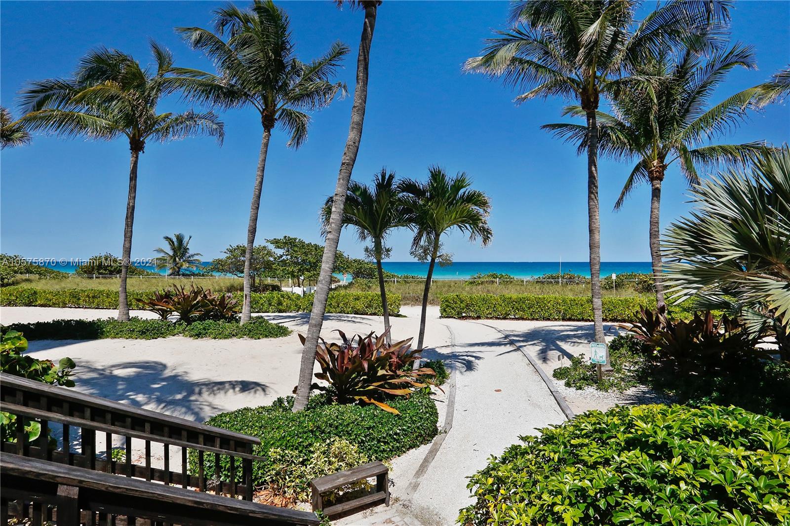 8925 Collins Avenue, Unit 9B Surfside, FL 33154 - Photo 26 of 46 a view of a garden with a table and chairs under an umbrella