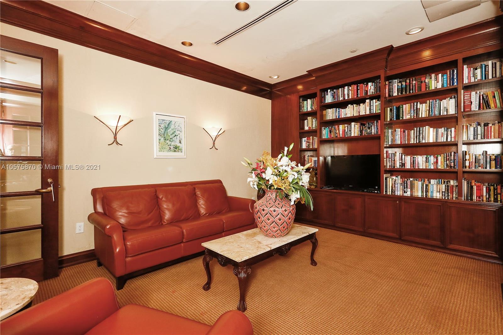 8925 Collins Avenue, Unit 9B Surfside, FL 33154 - Photo 34 of 46 a living room with furniture and a bookshelf with wooden floor
