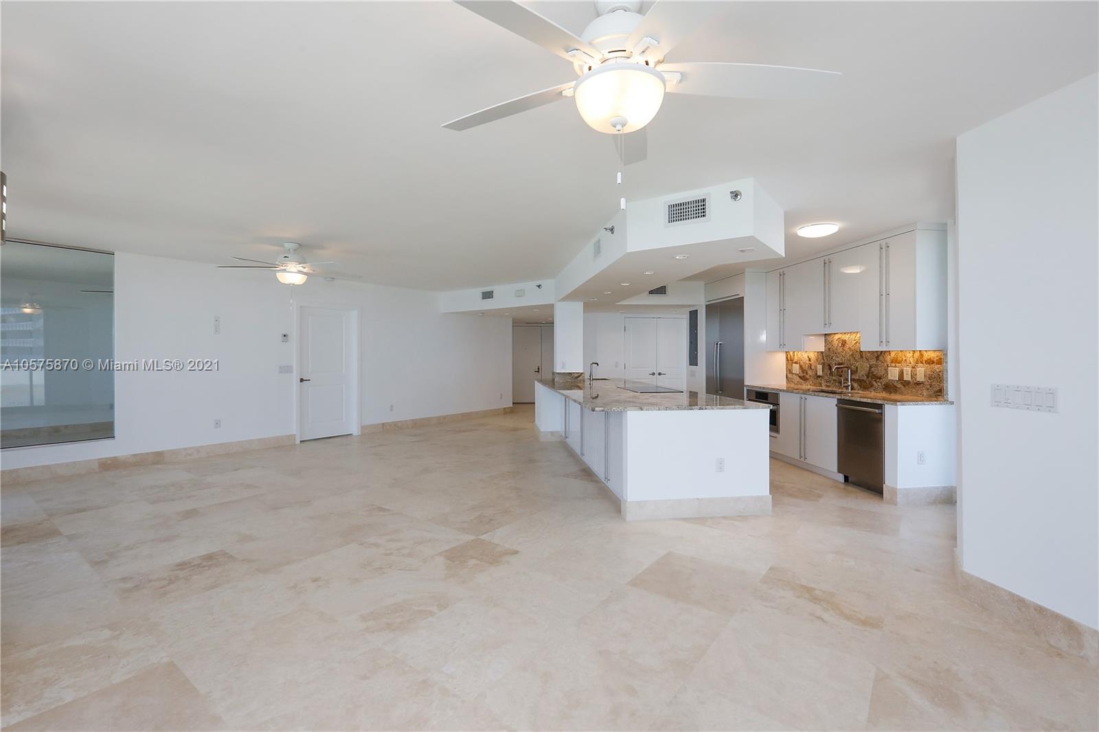 8925 Collins Avenue, Unit 9B Surfside, FL 33154 - Photo 5 of 46 a view of kitchen with kitchen island white cabinets and refrigerator