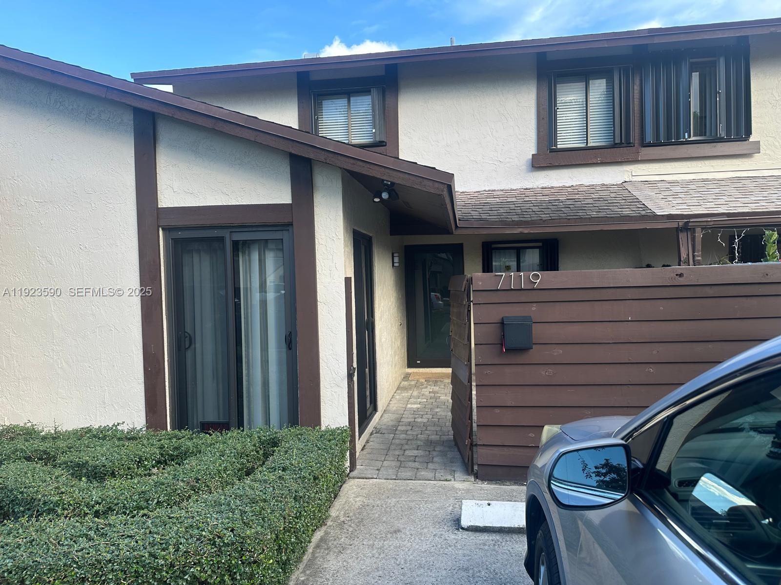 a view of a house with a door and a car parked in front of it