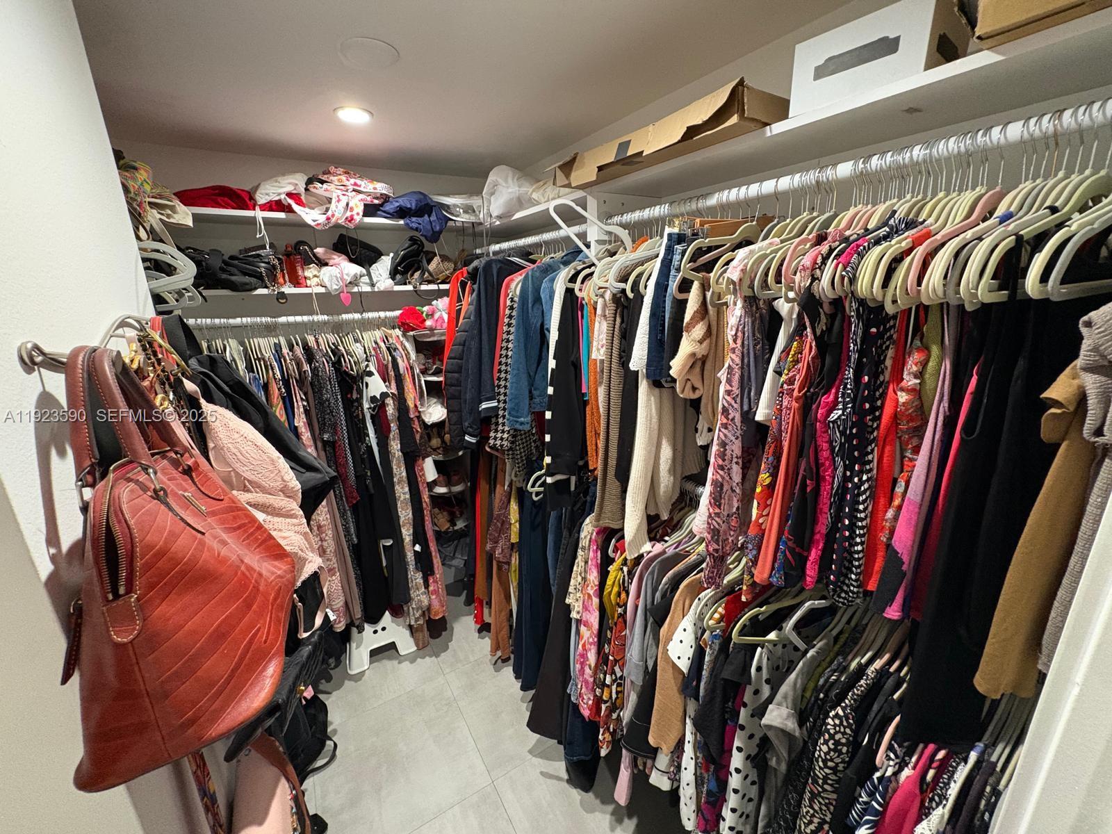 7119 Southwest 105th Court Miami, FL 33173 - Photo 13 of 19 a view of walk in closet with clothes and shoes