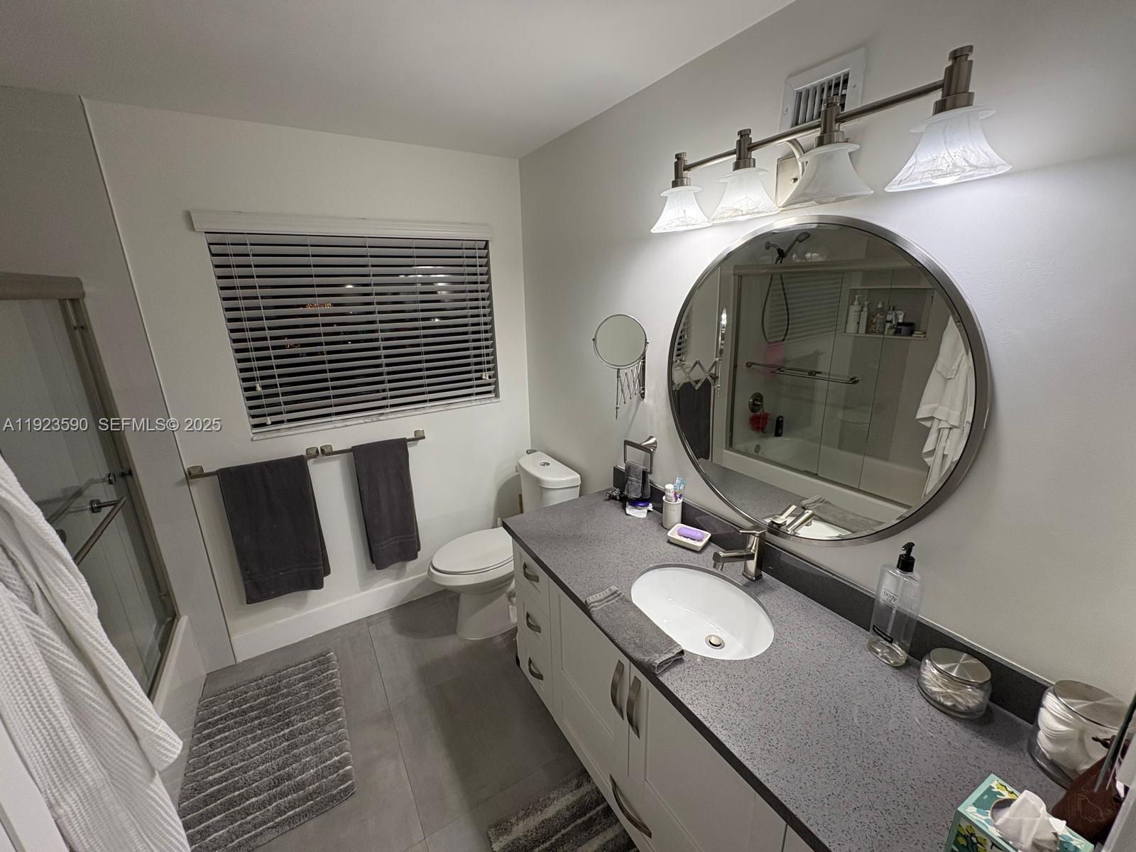 7119 Southwest 105th Court Miami, FL 33173 - Photo 14 of 19 a bathroom with a double vanity sink and mirror