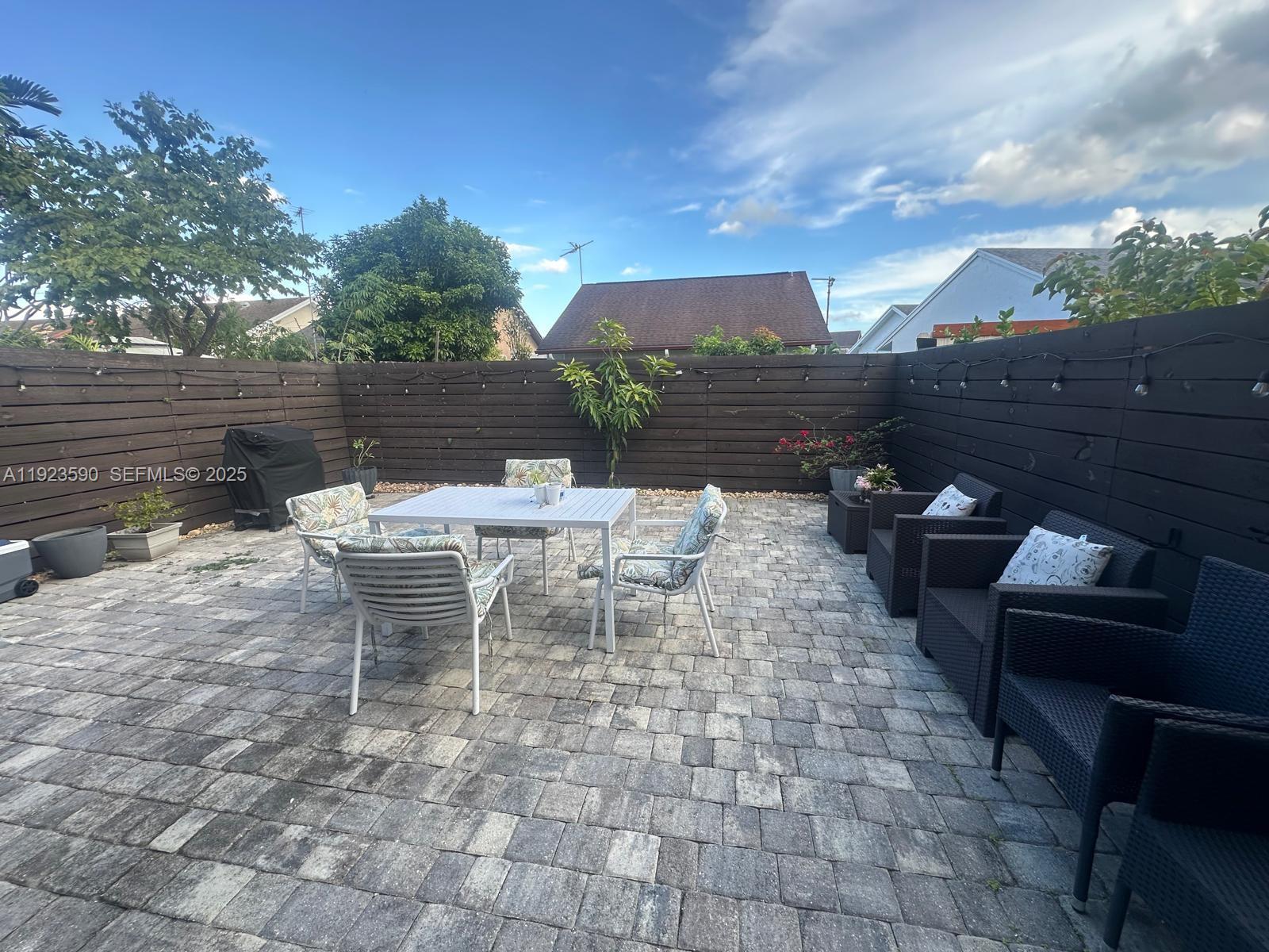 7119 Southwest 105th Court Miami, FL 33173 - Photo 18 of 19 a view of a patio with table and chairs with wooden floor and fence