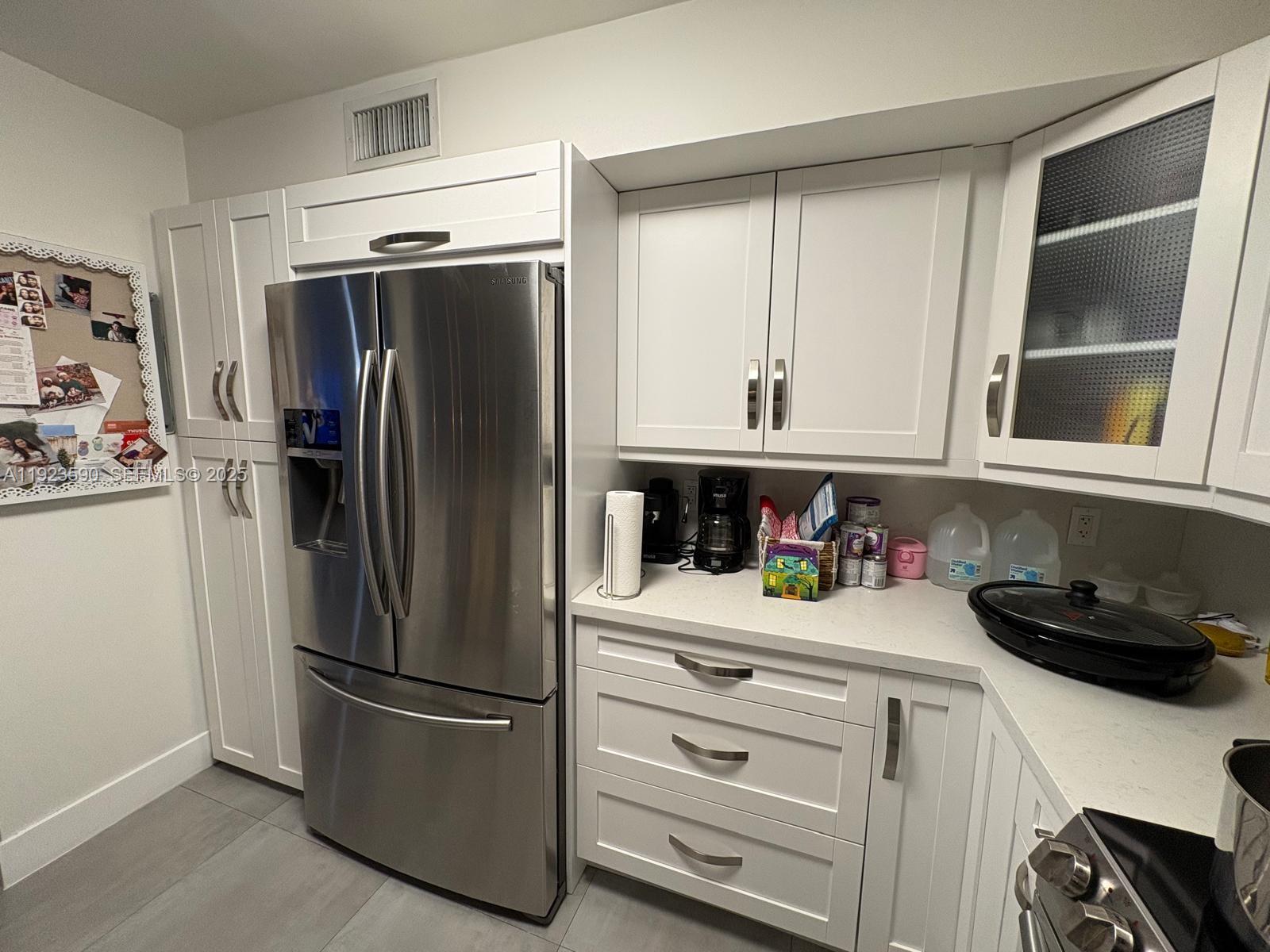 7119 Southwest 105th Court Miami, FL 33173 - Photo 4 of 19 a kitchen with a refrigerator and cabinets
