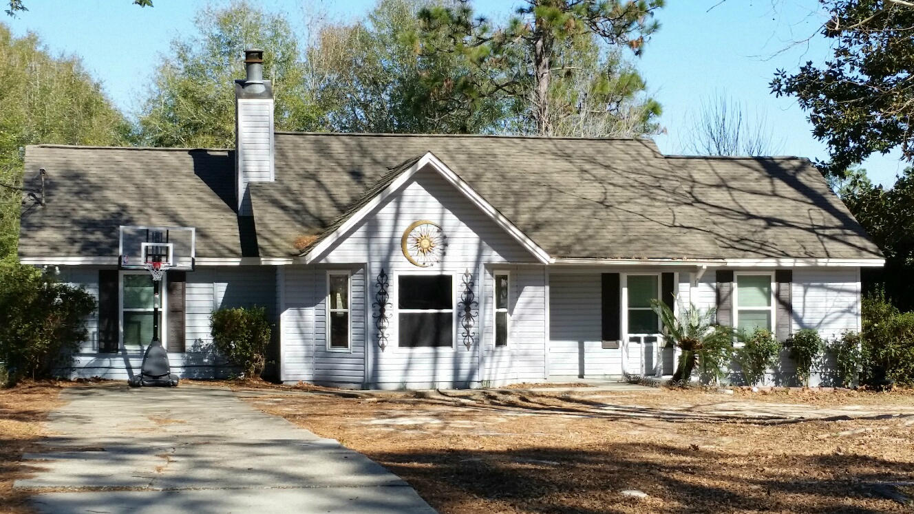 348 John King Road Crestview, FL 32539 - Photo 1 of 19 a view of a house with small yard plants and a large tree