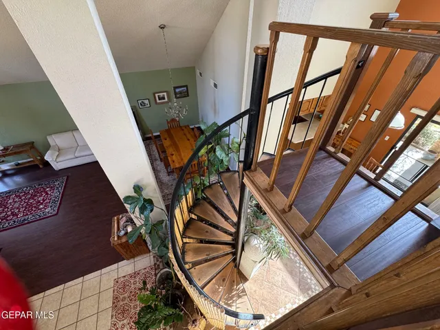 a room with stainless steel appliances a kitchen island hardwood floor and a view of living room