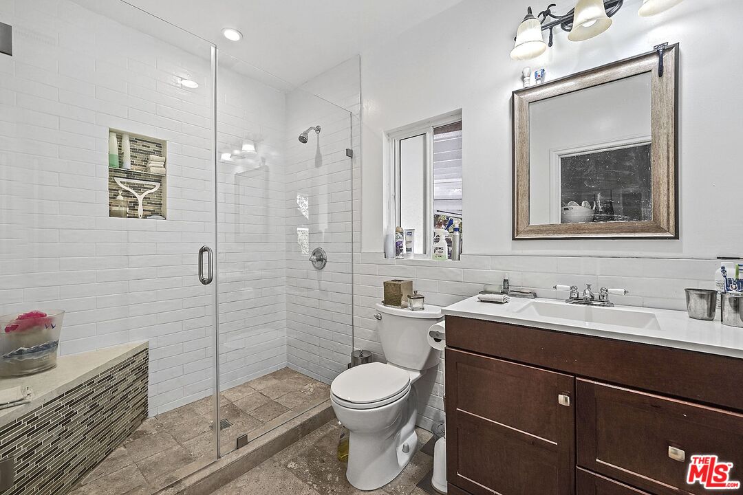 1945 Summit Avenue Pasadena, CA 91103 - Photo 11 of 15 a bathroom with a toilet a sink and mirror