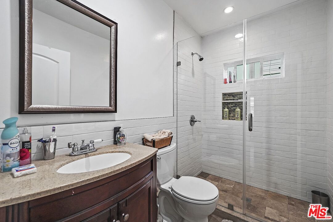 1945 Summit Avenue Pasadena, CA 91103 - Photo 10 of 15 a bathroom with a granite countertop toilet sink and mirror
