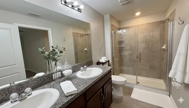a bathroom with a granite countertop sink toilet a mirror a shower and a tub