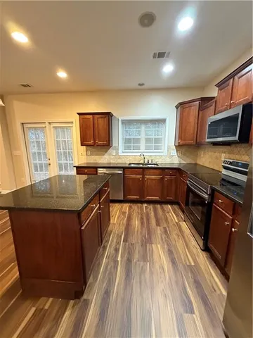 a kitchen with stainless steel appliances granite countertop a stove sink and cabinets