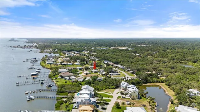 an aerial view of a city with lots of residential buildings and ocean view in back