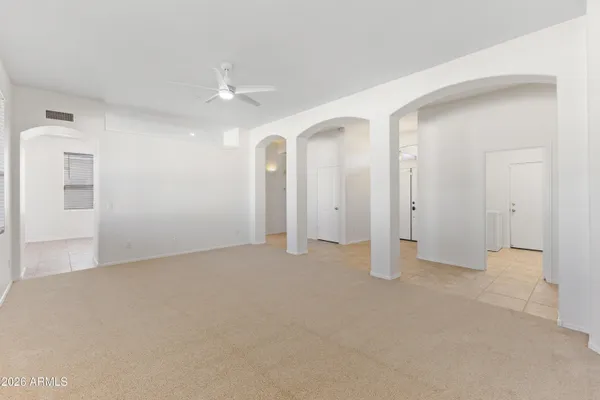 an empty room with chandelier fan