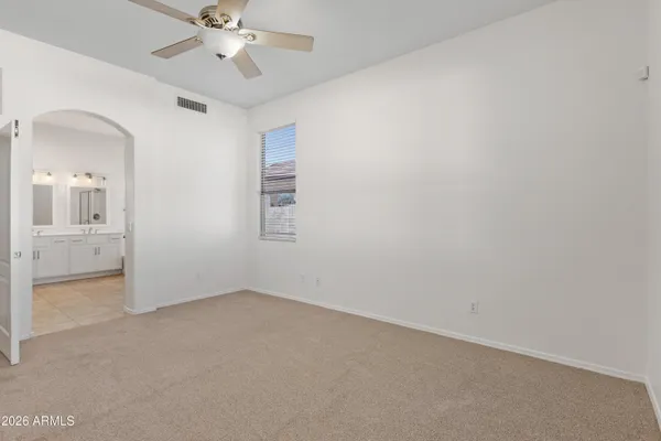 an empty room with fan and windows