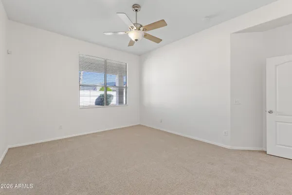 an empty room with window and ceiling fan