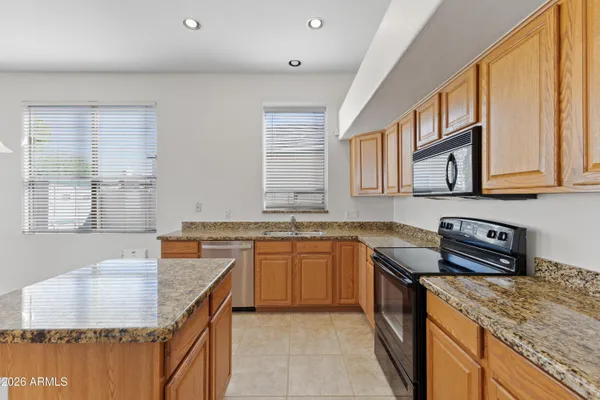a kitchen with stainless steel appliances granite countertop a sink stove and cabinets