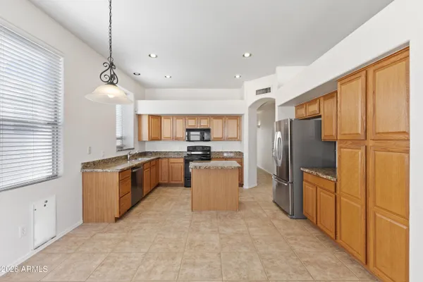 a large kitchen with stainless steel appliances a refrigerator and a stove