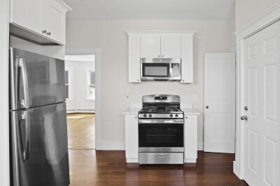 12 Redfield Street, Unit 3 Boston, MA 02122 - Photo 4 of 13 a kitchen with a refrigerator stove and wooden floor