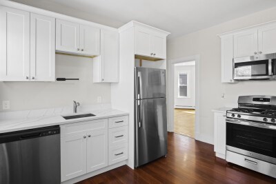 12 Redfield Street, Unit 3 Boston, MA 02122 - Photo 5 of 13 a kitchen with a refrigerator stove and wooden cabinets