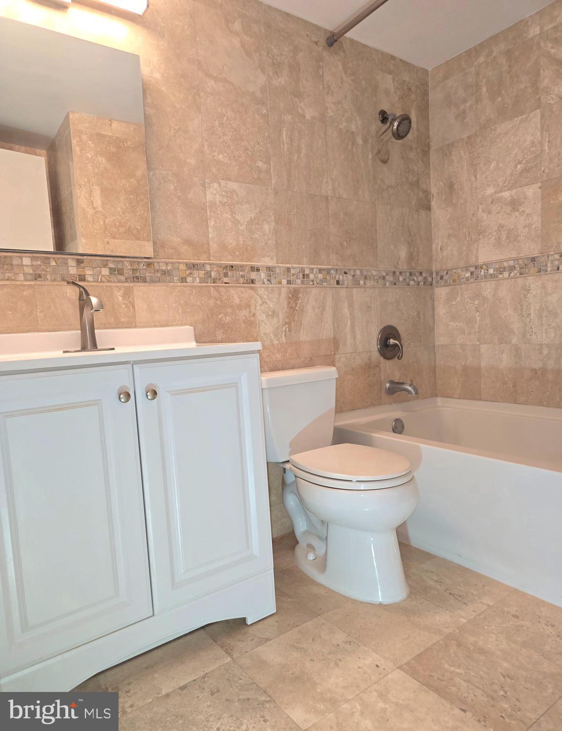 1425 4th Street Southwest, Unit A609 Washington, DC 20024 - Photo 8 of 12 a bathroom with a toilet a sink a mirror and bathtub