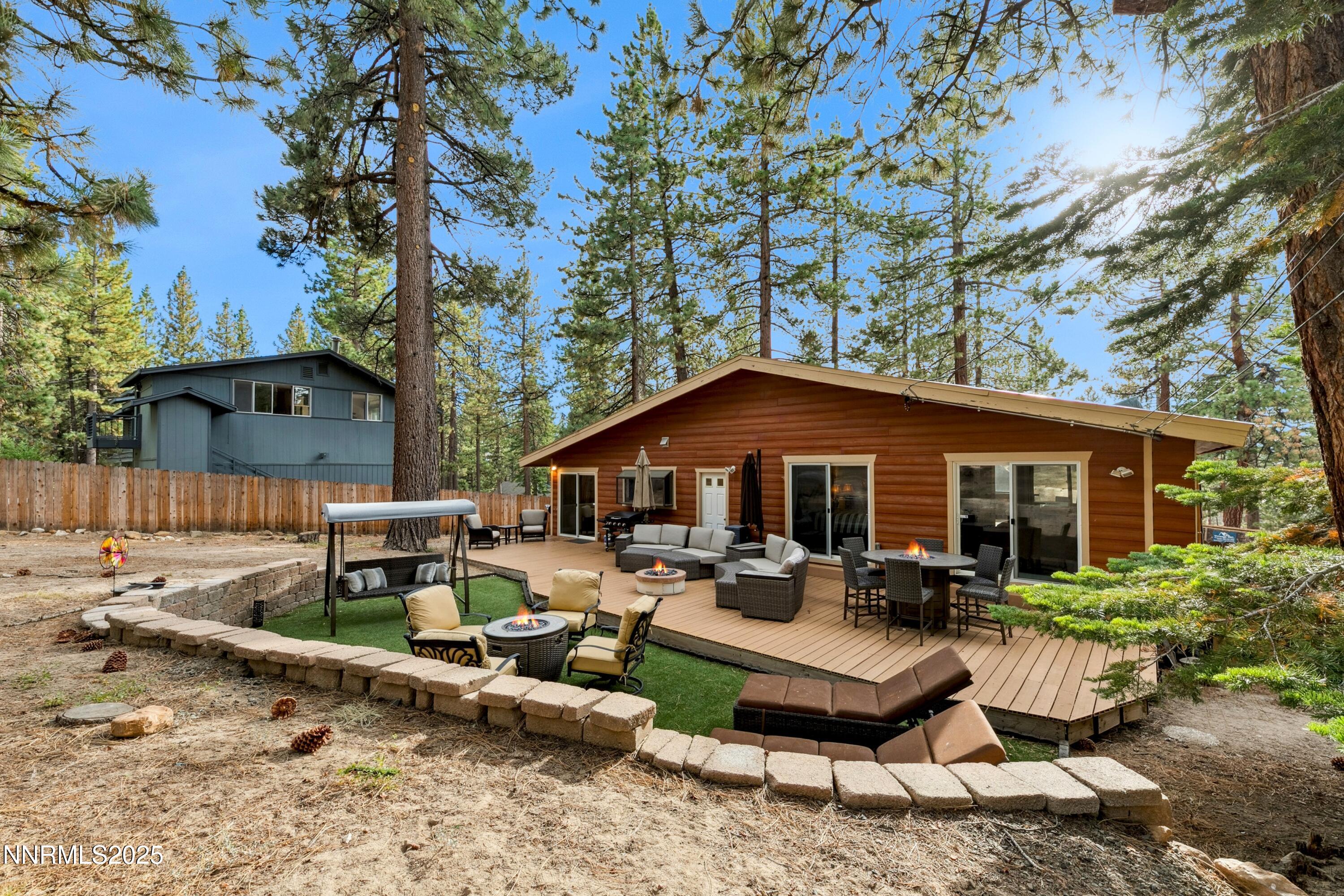 301 Chimney Rock Road Stateline, NV 89449 - Photo 26 of 38 a view of a patio with couches table and chairs under an umbrella with trees