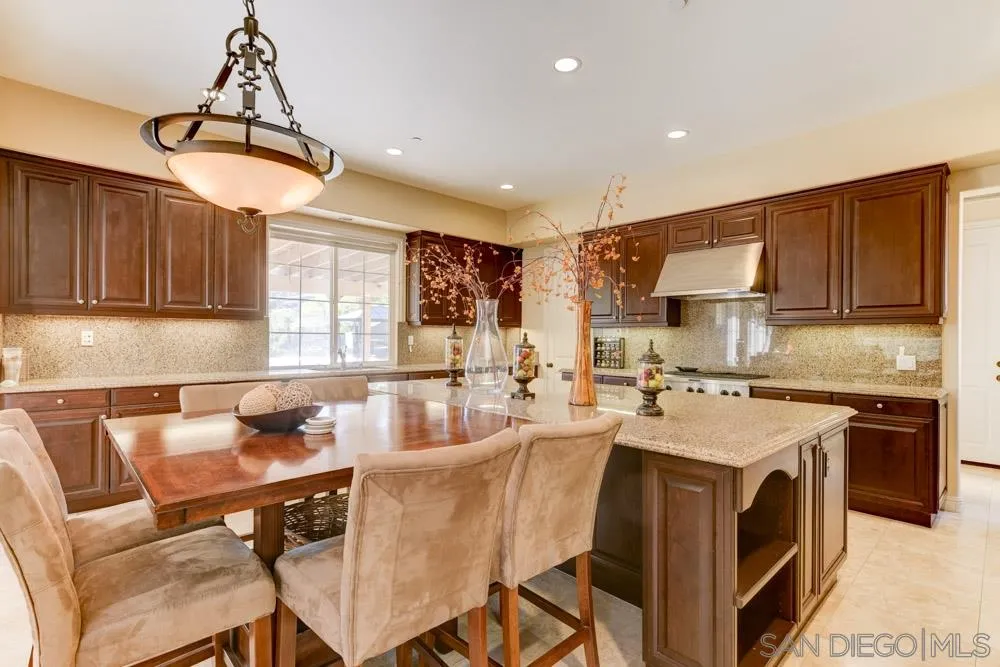 2936 Ranch Gate Road Chula Vista, CA 91914 - Photo 5 of 32 a kitchen with a dining table chairs stainless steel appliances and cabinets