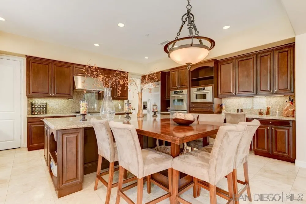 2936 Ranch Gate Road Chula Vista, CA 91914 - Photo 10 of 32 a dining room with stainless steel appliances granite countertop a dining table chairs and a refrigerator