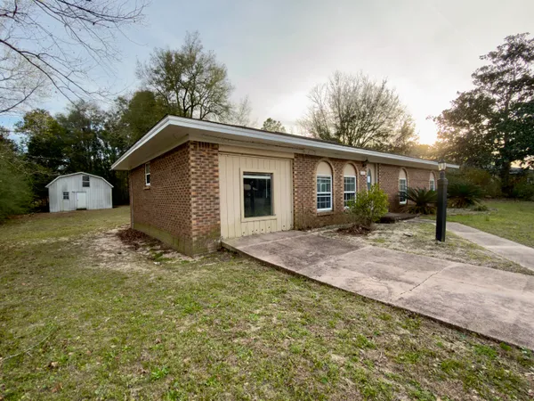 a view of a house with backyard and trees