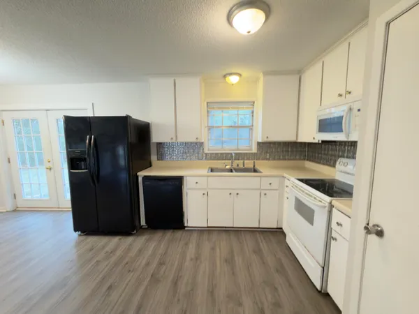 a kitchen with a refrigerator sink and cabinets