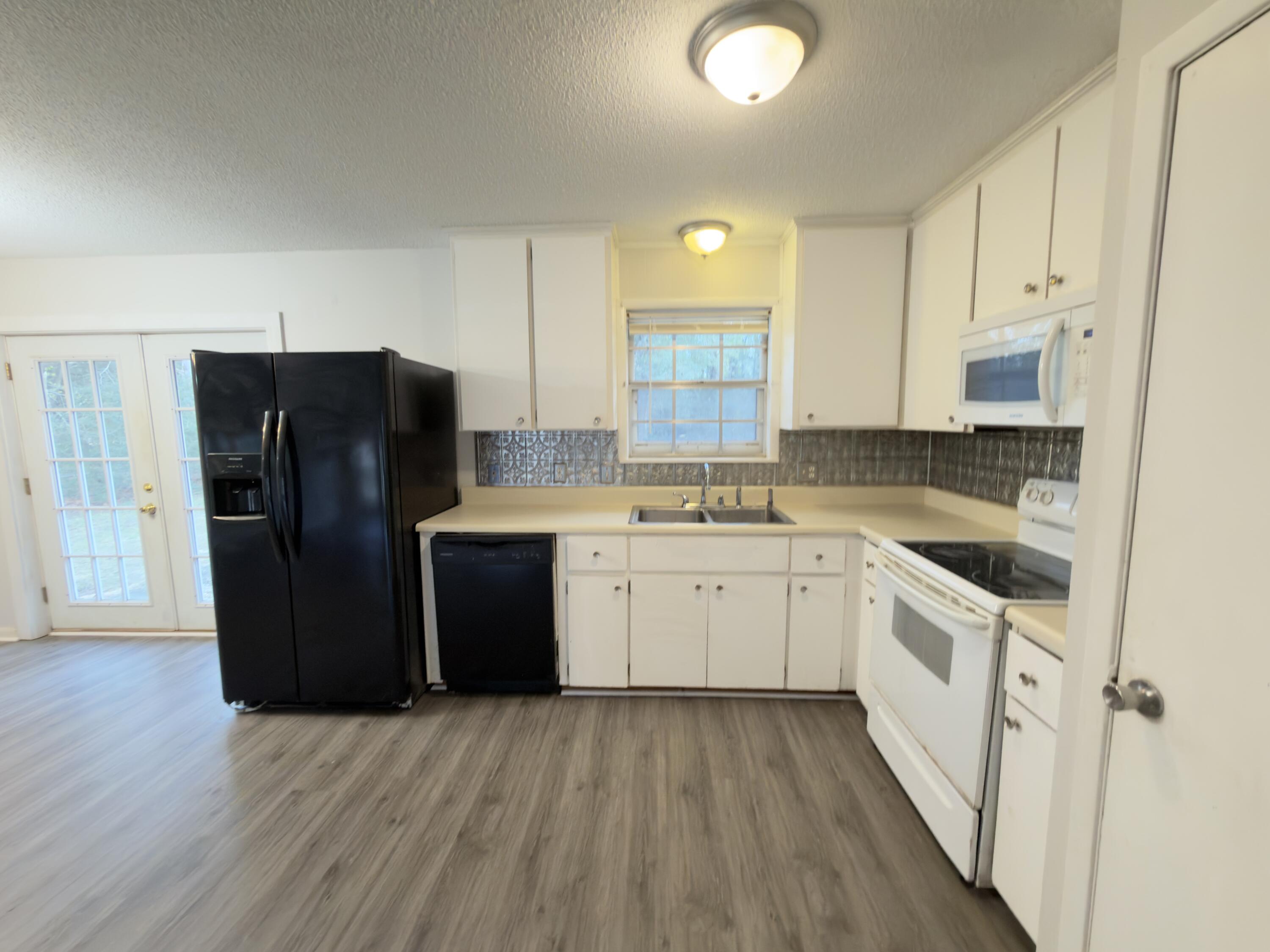 208 Forrest Parkway Crestview, FL 32539 - Photo 3 of 17 a kitchen with a refrigerator sink and cabinets