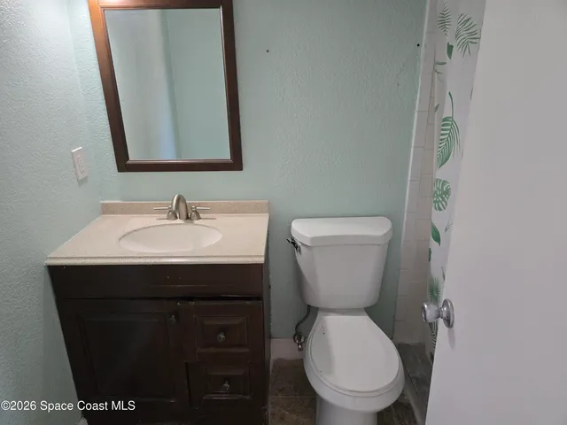 a bathroom with a toilet and shower curtain