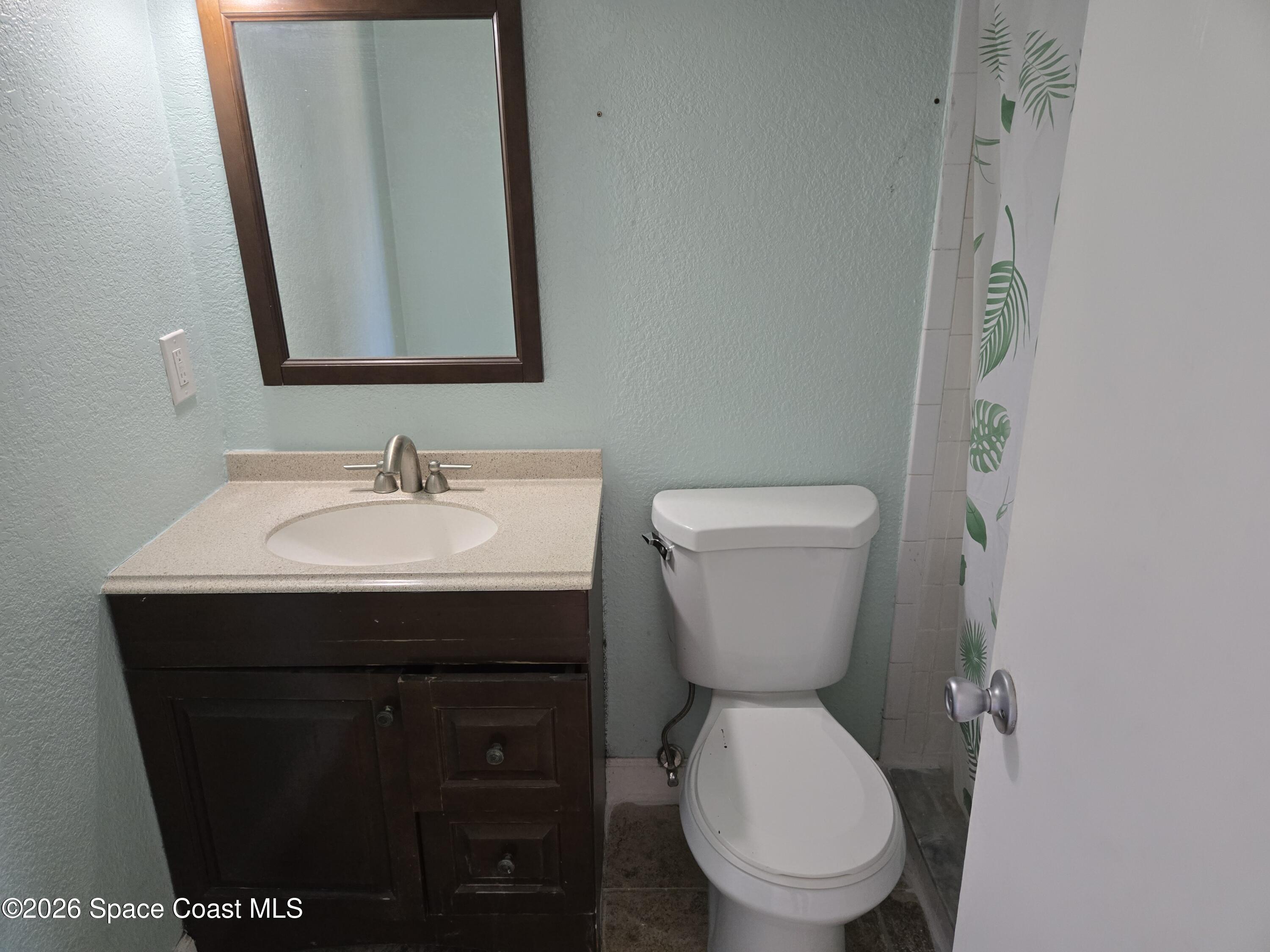 174 Ulster Lane Melbourne, FL 32935 - Photo 15 of 25 a bathroom with a toilet sink and mirror