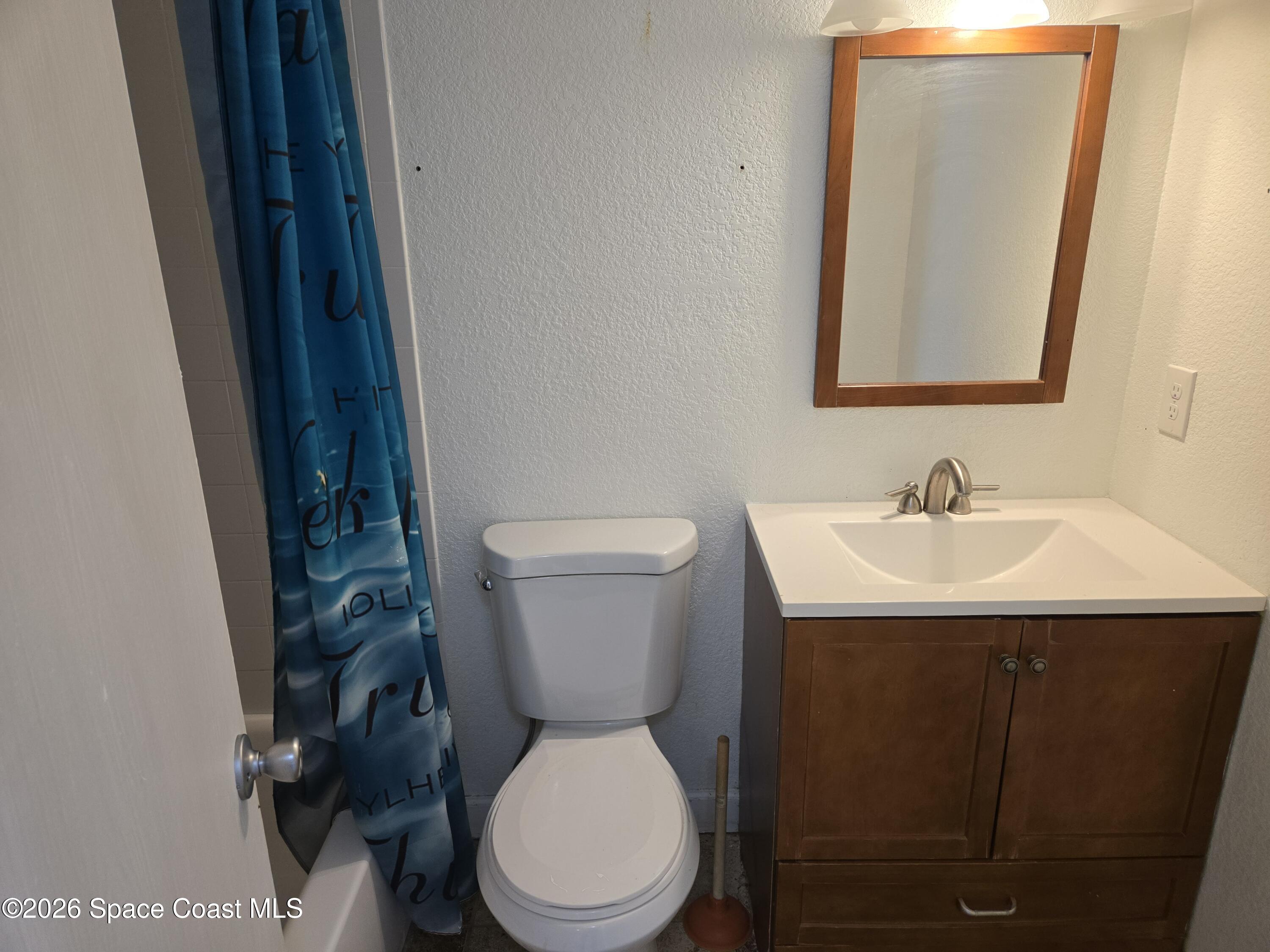174 Ulster Lane Melbourne, FL 32935 - Photo 19 of 25 a white toilet sitting next to a bathroom sink