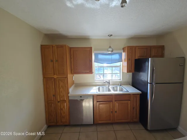 a kitchen with refrigerator and cabinets