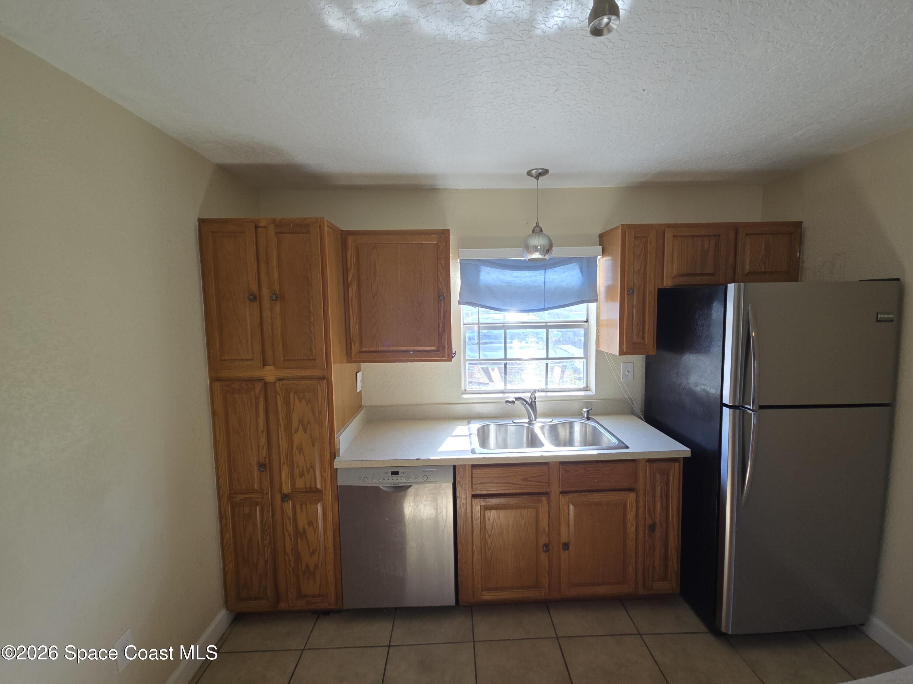 174 Ulster Lane Melbourne, FL 32935 - Photo 7 of 25 a kitchen with refrigerator and cabinets