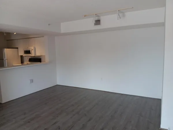 a view of a kitchen with wooden floor and electronic appliances